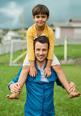 Buy stock photo Portrait of a cheerful father carrying his young son on his shoulders outdoors