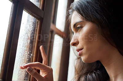 Buy stock photo Thinking, lonely and woman in window by rain, winter weather and water with drops for gloomy atmosphere. Home, sad and female person with seasonal affective disorder, low energy and climate change