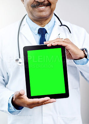 Buy stock photo Shot of an unrecognizable male doctor holding up a digital tablet in front of him inside of a hospital during the day