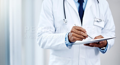 Buy stock photo Shot of an unrecognizable male doctor using a digital tablet inside of a hospital during the day