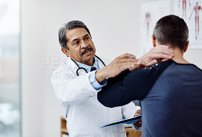 Buy stock photo Shot of a confident mature male doctor doing a checkup on a patient inside of a hospital during the day
