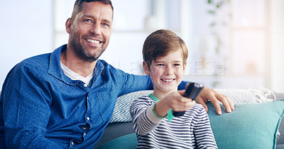 Buy stock photo Shot of a cheerful father and son relaxing on a couch and spending some time together indoors