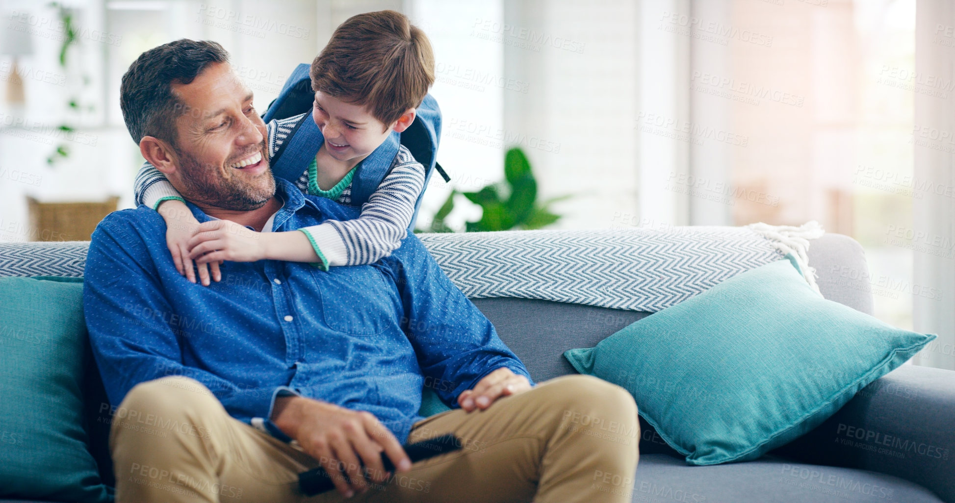 Buy stock photo Dad, child and hug in a family home with love and care on living room sofa with a smile after school. A man or dad with a kid or son together on a couch for quality time, bonding and fathers day