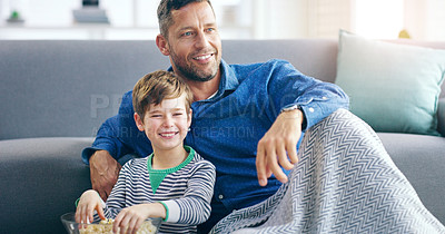 Buy stock photo Relax, dad and son watching tv on sofa in home with popcorn, online video or streaming movie together. Film, father and child on couch for television, cartoon subscription, smile and weekend bonding