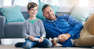 Buy stock photo Happy father, child and playing video games for fun bonding, holiday or weekend together on the living room floor at home. Dad and kid smiling in joyful happiness for console gaming or entertainment