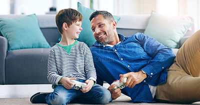 Buy stock photo Father, child and playing video games for fun bonding, laughing or time together on living room floor at home. Happy dad and kid smiling with laugh for funny family, son or gaming entertainment