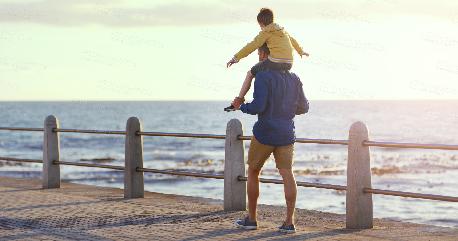 Buy stock photo Father, child and piggyback by the beach in sunset for family bonding, playing or fun holiday or weekend in nature. Dad carrying kid on back walking by ocean coast for summer time together outdoors