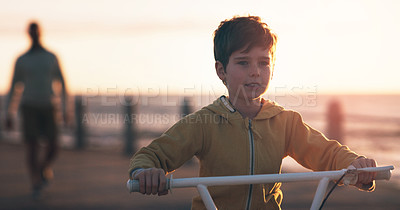 Buy stock photo Boy, bike and learning at beach on holiday, promenade and sunset sky with father for care, love or bonding. Man, child and bicycle with support, teaching and smile outdoor by sea, vacation and summer