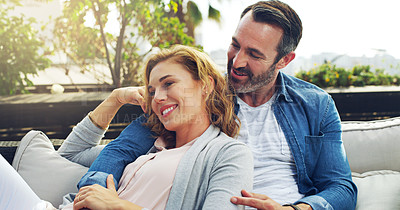 Buy stock photo Hug, relax and couple on hotel terrace with smile, love and tropical holiday fun together. Laughing, man and happy woman on outdoor couch with embrace, cozy romance and date on calm travel vacation.