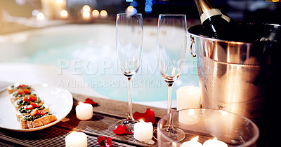 Buy stock photo Shot of a beautiful setting of champagne and treats near a hot tub at night