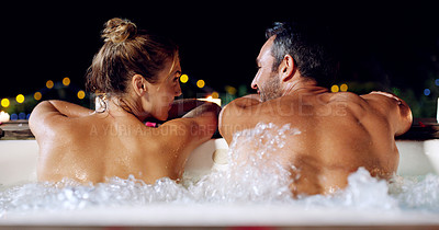 Buy stock photo Rearview shot of an affectionate mature couple relaxing in a hot tub together at night