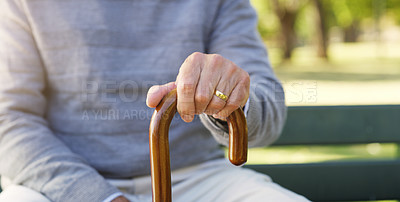 Buy stock photo Closeup shot of an unrecognizable senior man holding onto his walking stick outdoors