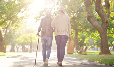 Buy stock photo Walking, park and and woman with elderly mother for bonding, assistance and help outdoors. Nature, family and female person with disability with cane and adult daughter for wellness, relax or support