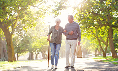 Buy stock photo Senior couple, cane and walking outdoor at a park with a love, care and support for health and wellness. A elderly man and woman in nature for a walk, quality time and healthy marriage or retirement