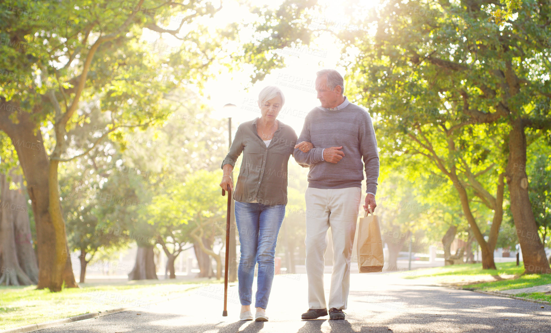 Buy stock photo Senior couple, cane and walking outdoor at a park with a love, care and support for health and wellness. A elderly man and woman in nature for a walk, quality time and healthy marriage or retirement
