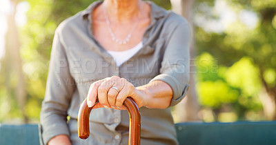 Buy stock photo Elderly woman, park and hand with cane in nature for mobility support, balance and healthcare. Garden, sunshine and walking stick of person with a disability on bench for retirement, help and peace