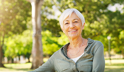 Buy stock photo Cropped portrait of a happy senior woman sitting alone at the park