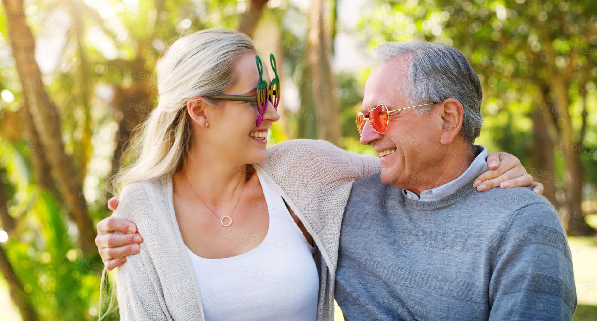 Buy stock photo Mature man, daughter and nature for hug, outdoor and embrace with funky eyewear. Woods, forest and glasses with smile for bonding with family, summer and love for dad and woman in home garden 