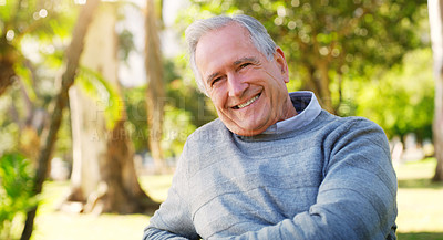 Buy stock photo Cropped portrait of a happy senior man siting alone at the park