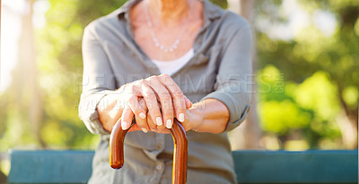 Buy stock photo Senior woman, park and hand with cane in nature for mobility support, healthcare and balance. Sunshine, garden and walking stick of person with a disability on bench for peace, help and retirement