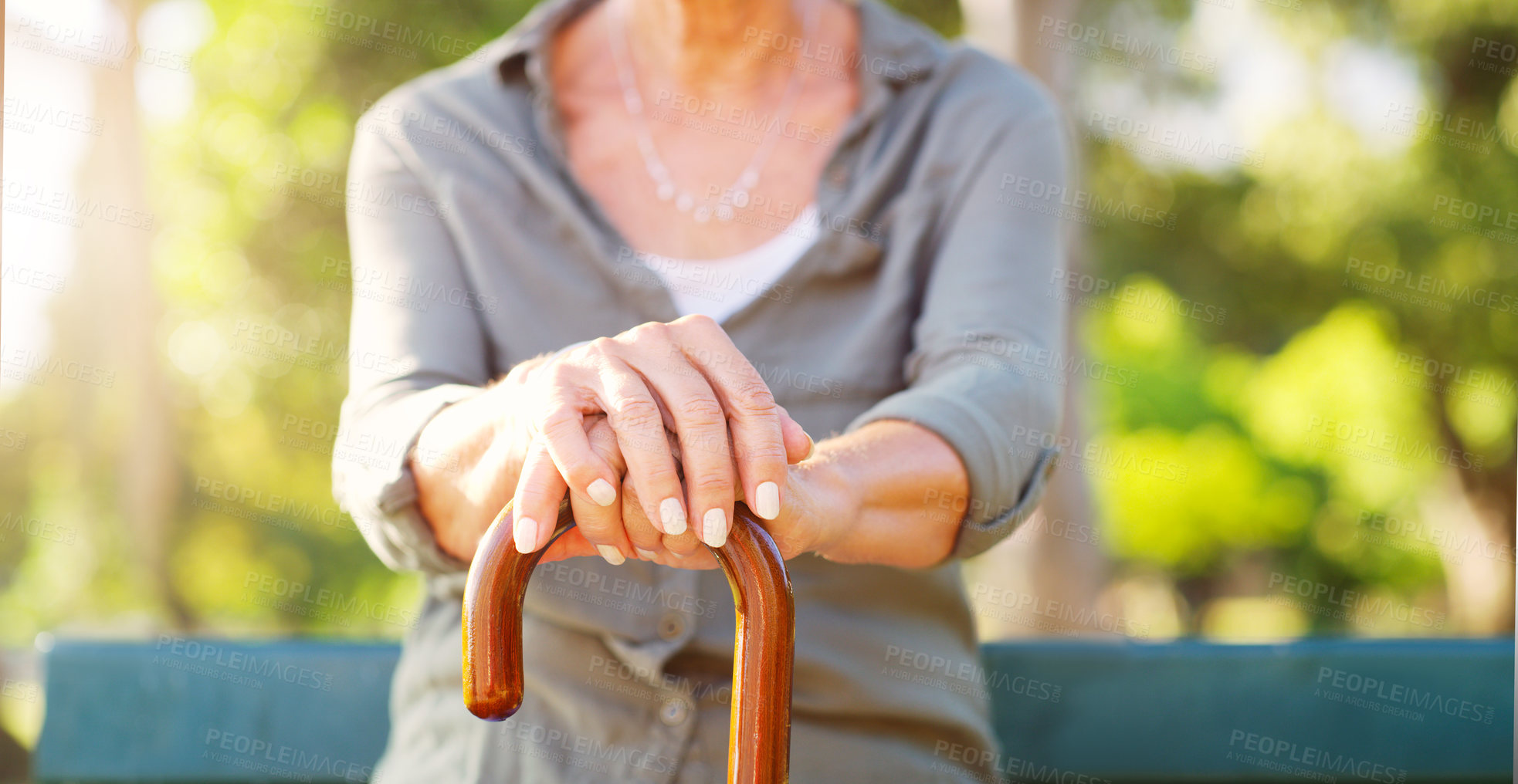 Buy stock photo Senior woman, park and hand with cane in nature for mobility support, healthcare and balance. Sunshine, garden and walking stick of person with a disability on bench for peace, help and retirement