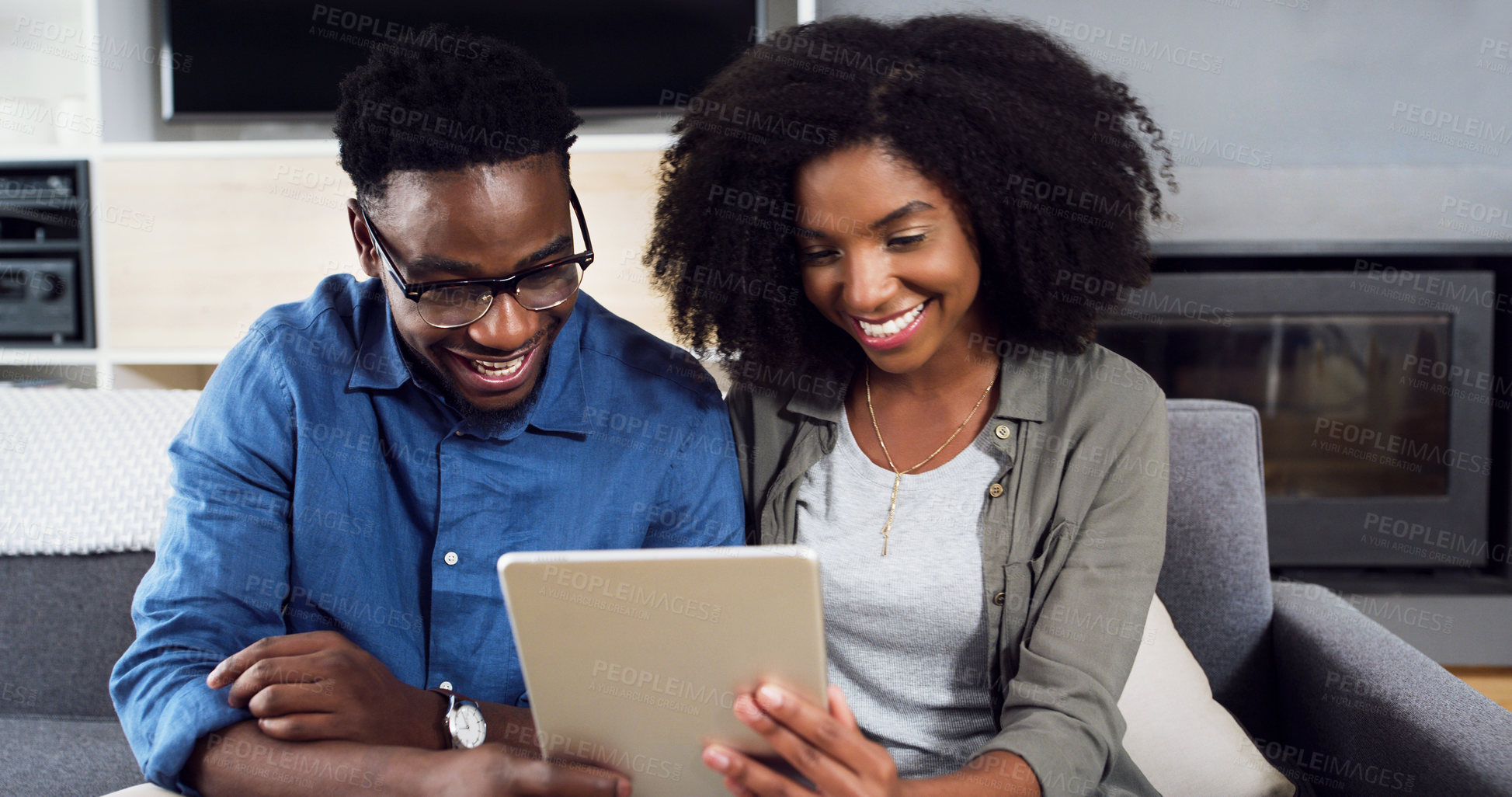 Buy stock photo Shot of a cheerful  young couple using a digital tablet together at home