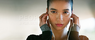 Buy stock photo Cropped portrait of an attractive young woman listening to music while working out outdoors