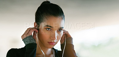 Buy stock photo Fitness, focus and woman with earphones for streaming music, listening to podcast or radio station. Serious, sport and female athlete for running, morning workout or cardio exercise on banner