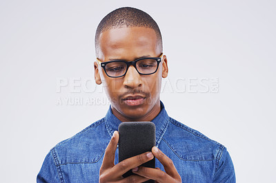 Buy stock photo Phone, communication and serious black man in studio typing for social media post, internet and online chat. Mockup, white background and male person on smartphone for website, mobile app and network