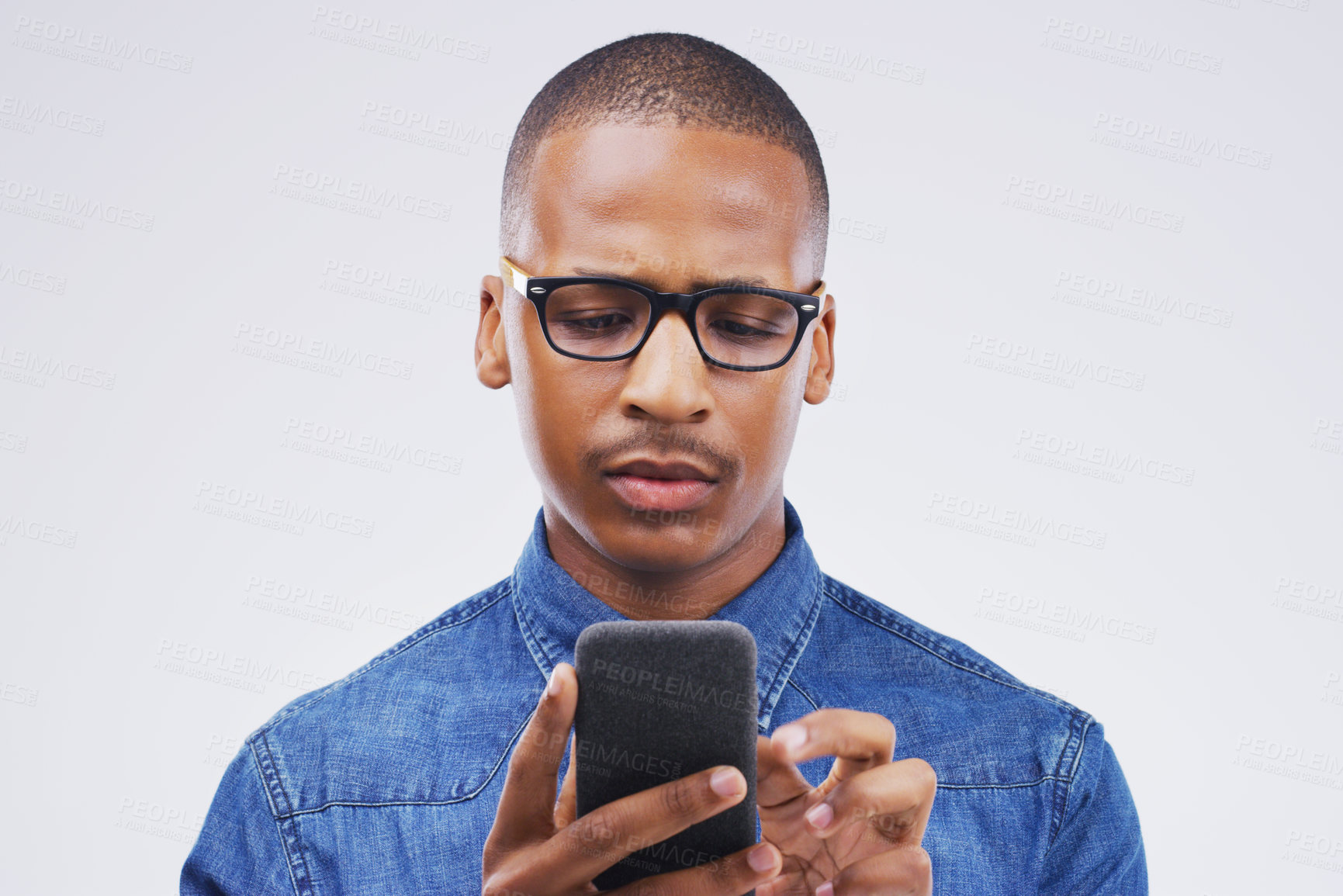 Buy stock photo Phone, communication and serious black man in studio typing for social media, internet and online chat. Mockup, white background and male person on smartphone for website, mobile app and network