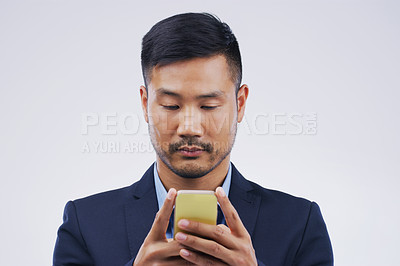 Buy stock photo Serious, phone and Asian business man in studio isolated on a white background. Mobile, cellphone and male person typing for email, web scroll or browsing online, social media or internet app to text