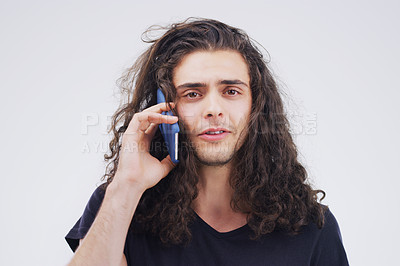 Buy stock photo Studio shot of a young man using a mobile phone against a grey background