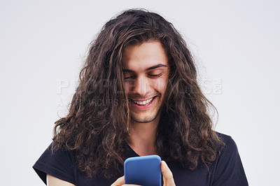 Buy stock photo Phone, happy and man typing online in studio with smile for social media, internet and chatting. Communication mockup, white background and male person on smartphone for website, mobile app and text
