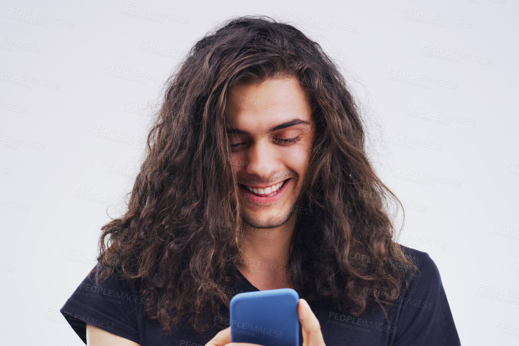 Buy stock photo Phone, happy and man typing online in studio with smile for social media, internet and chatting. Communication mockup, white background and male person on smartphone for website, mobile app and text