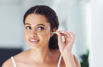 Buy stock photo Cropped shot of an attractive young woman cleaning her ears with a cotton bud