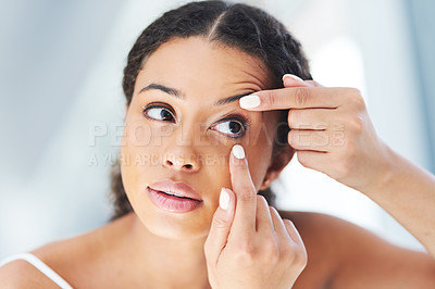 Buy stock photo Cropped shot of an attractive young woman going through her morning beauty routine in the bathroom