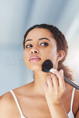 Buy stock photo Cropped shot of a young woman applying makeup to her cheeks in the bathroom at home
