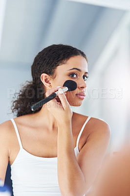 Buy stock photo Cropped shot of a young woman applying makeup to her cheeks in the bathroom at home
