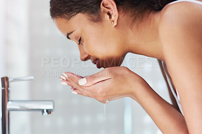 Buy stock photo Cropped shot of a young woman washing her face in the bathroom at home