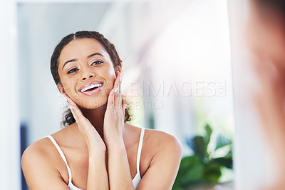 Buy stock photo Cropped shot of an attractive young woman touching her face during her morning routine