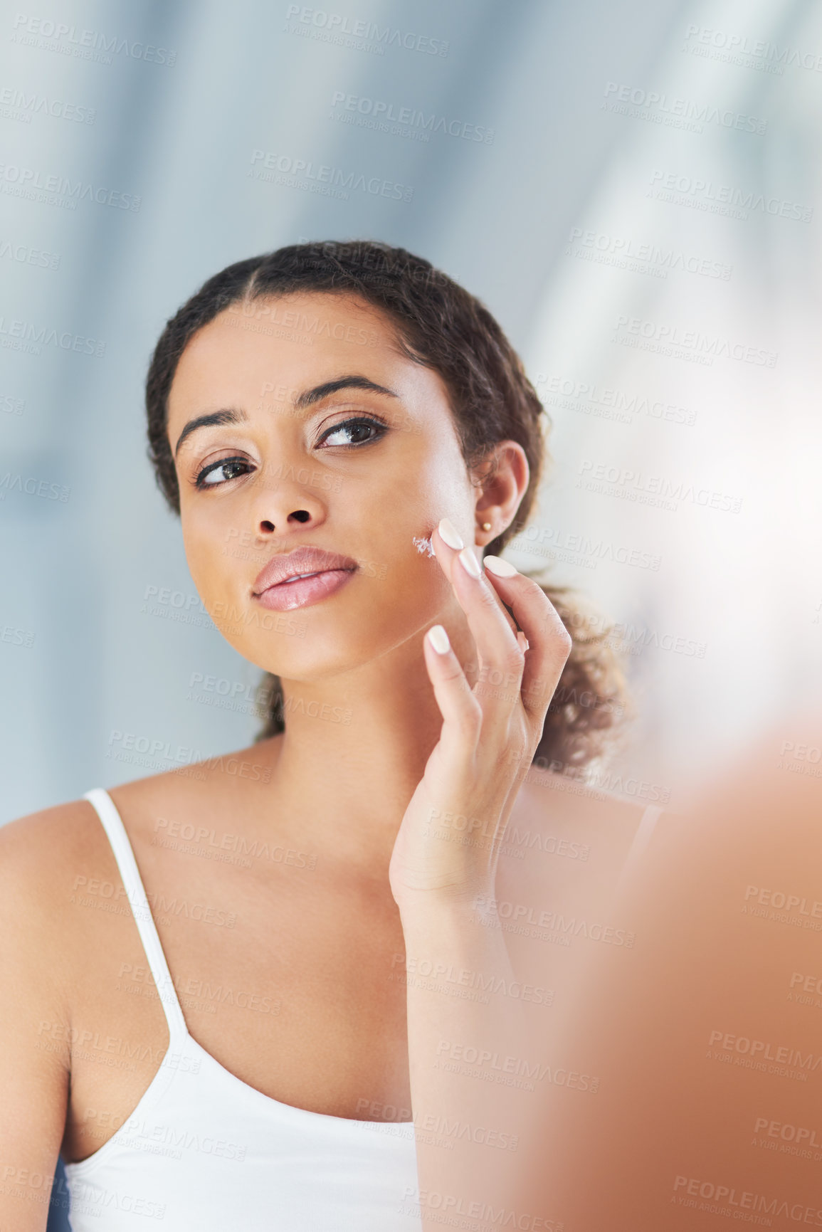 Buy stock photo Cropped shot of an attractive young woman going through her morning beauty routine in the bathroom