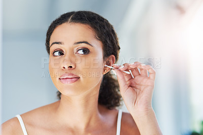Buy stock photo Cropped shot of an attractive young woman cleaning her ears with a cotton bud