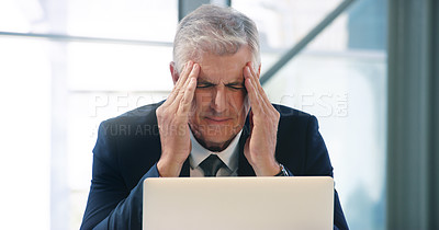 Buy stock photo Shot of a mature businessman looking stressed out while working in an office