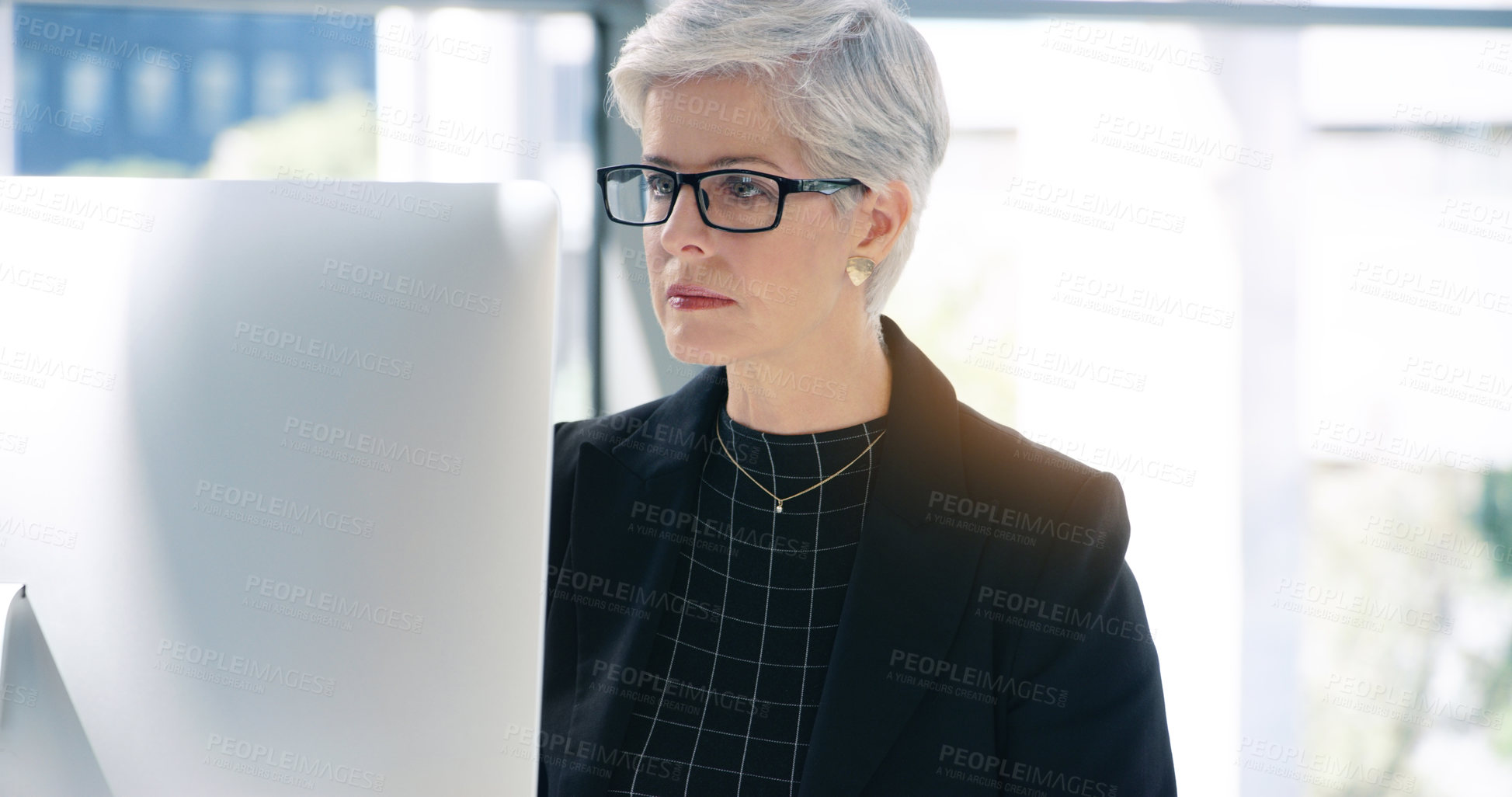 Buy stock photo Shot of a mature businesswoman working on a computer in an office