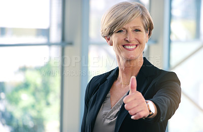 Buy stock photo Portrait of a mature businesswoman showing thumbs up in an office