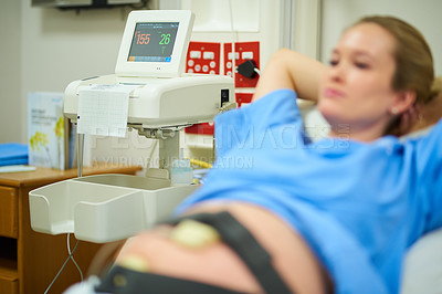 Buy stock photo Shot of a young pregnant woman lying back in her hospital bed on her due date