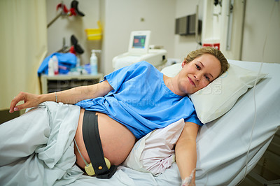 Buy stock photo Portrait of an attractive young pregnant woman lying in her hospital bed on her due date