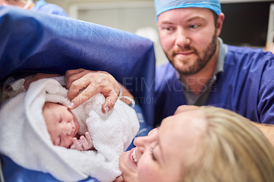 Buy stock photo Shot of a beautiful young couple welcoming their newly born baby girl in the hospital