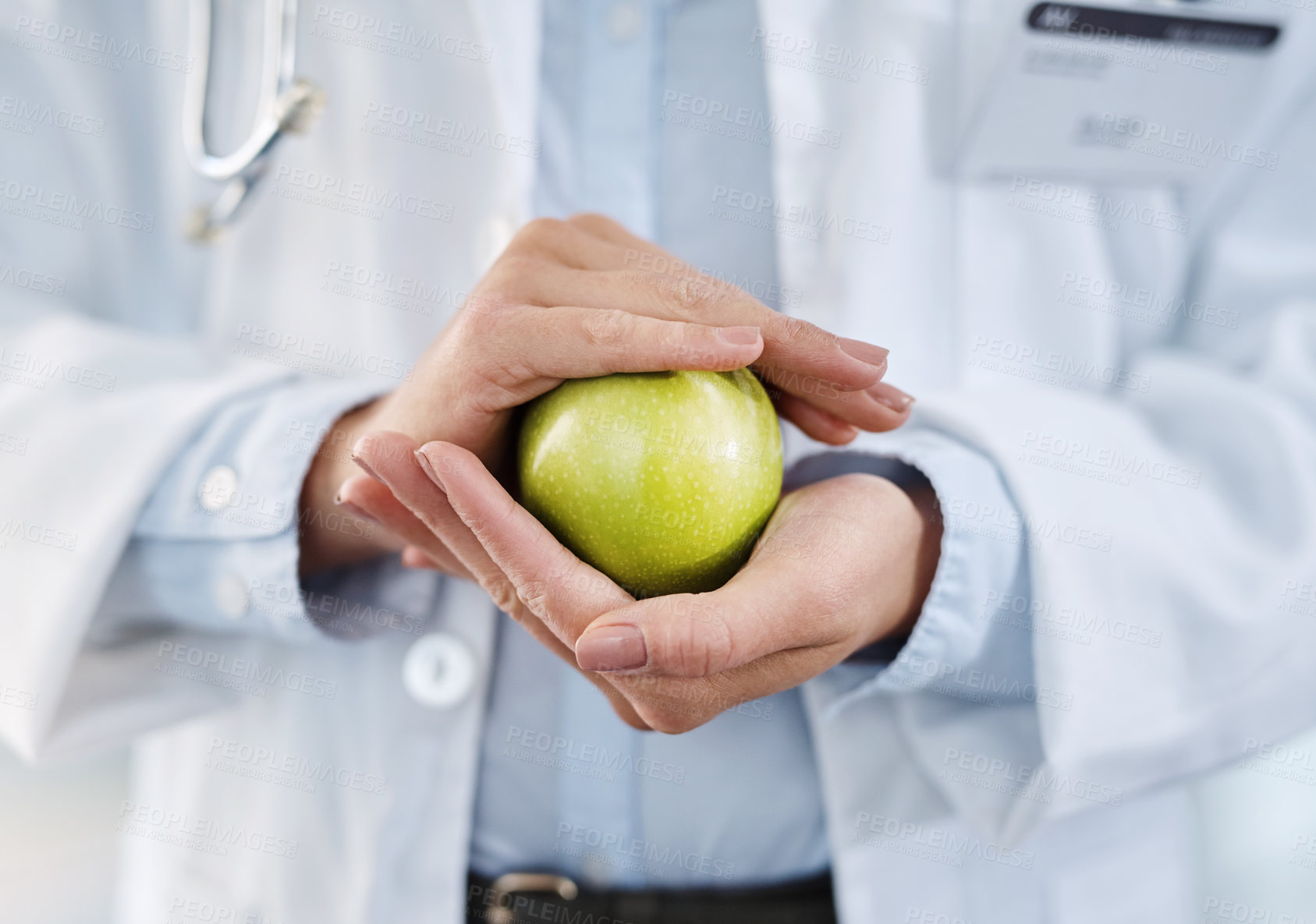 Buy stock photo Closeup shot of an unidentifiable doctor holding an apple