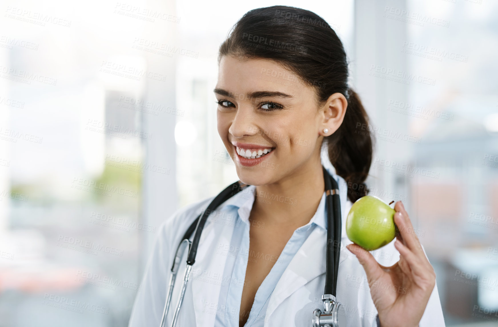 Buy stock photo Doctor, portrait and happy woman with apple for nutrition, healthy diet or wellness. Face, nutritionist or medical professional with fruit for advice, healthcare or natural food for vegan benefits